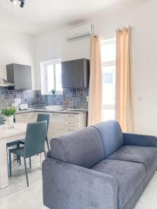 a living room with a blue couch and a kitchen at 1 Bedroom Penthouse in Gzira in Il-Gżira