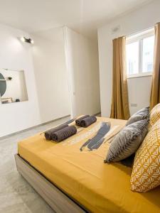 a large yellow bed with two pillows on it at 1 Bedroom Penthouse in Gzira in Il-Gżira