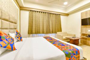 a hotel room with a bed and a desk at FabHotel Hill Park in Ahmedabad