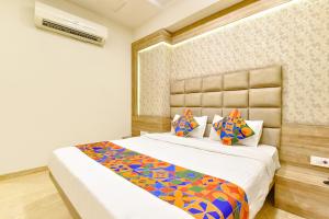 a bedroom with a large bed with a white bedspread at FabHotel Hill Park in Ahmedabad
