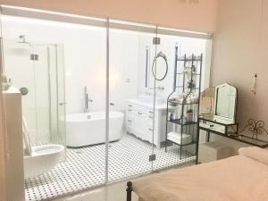 a bathroom with a shower and a tub and a sink at Boutique Penthouse by Weizmann - פנטהאוס בוטיק in Rechovot