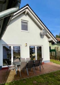 a table and chairs in front of a white house at Meermaid 1 in Plau am See