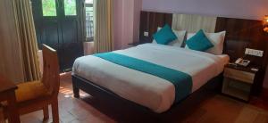 a bedroom with a large bed with blue pillows at The Red House Bandipur in Bandipur