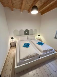 a white bedroom with a large white bed with blue sheets at Meermaid 1 in Plau am See
