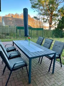 una mesa de picnic azul con cuatro sillas alrededor en Meermaid 1, en Plau am See