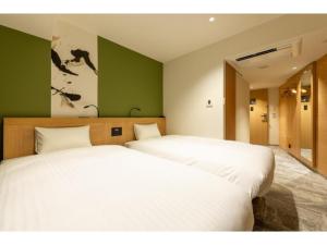 two beds in a room with green walls at The OneFive Kyoto Shijo - Vacation STAY 41807v in Kyoto