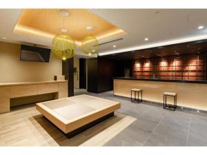 a lobby with a bed and a bar with stools at The OneFive Kyoto Shijo - Vacation STAY 41807v in Kyoto