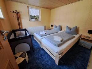 a bedroom with two beds and a television in it at Haus Erna Schierke in Schierke