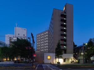 un grand bâtiment avec un feu de circulation devant lui dans l'établissement The OneFive Okayama - Vacation STAY 41839v, à Okayama