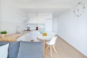 eine weiße Küche mit einem weißen Tisch und Stühlen in der Unterkunft Apartamento ESTRELLA con vistas a la piscina in Torrevieja