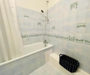 ein weißes Badezimmer mit einer Badewanne und einem Waschbecken in der Unterkunft Appartement Petit Messier in Senones