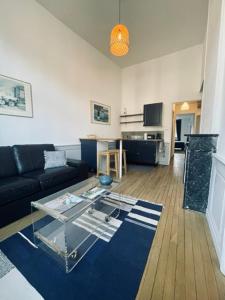 ein Wohnzimmer mit einem Sofa und einem Glastisch in der Unterkunft Appartement Petit Messier in Senones