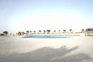 a shadow of a palm tree on a beach at Sidra Resort in Buqayq