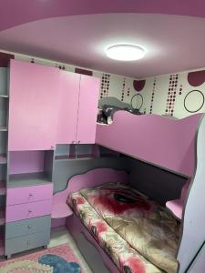 una camera per bambini con letto rosa e armadi di Apartament CASA ALEXIA a Botoşani