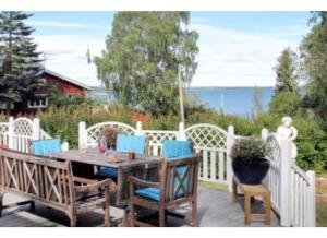 eine Terrasse mit einem Holztisch und Stühlen in der Unterkunft Modern stuga med sjöutsikt in Hammarby