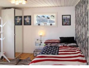 a room with a bed with an american flag on it at Modern stuga med sjöutsikt in Hammarby