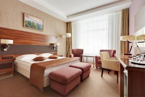 una camera d'albergo con letto, tavolo e sedie di Victoria Olimp Hotel & Business centre Minsk a Minsk