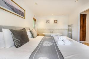 a bedroom with a large white bed with a sink at Bay Tree Lodge 02 in Narberth