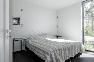a bedroom with a bed with a striped blanket at Seaview villa with jacuzzi in Töfsala