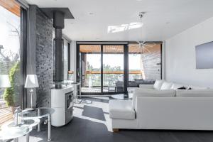 a living room with a white couch and a fireplace at Seaview villa with jacuzzi in Töfsala