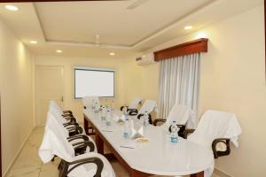 a conference room with a long white table and chairs at Hotel Vrindavan in Wayanad