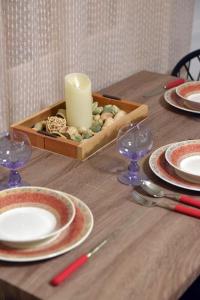un tavolo in legno con piatti e una candela di Nefeli House Syros a Ermoupoli