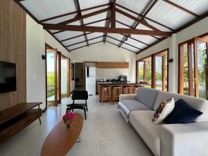uma sala de estar com um sofá e uma cozinha em Casa do Bem - Deluxe 3 bedroom villa with pool. em Pipa