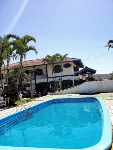 a large blue swimming pool in front of a house at condominio colonial pousada mariscal in Canto Grande