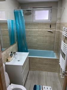 uma casa de banho com uma banheira, um lavatório e um WC. em Mary's Apartment em Suceava