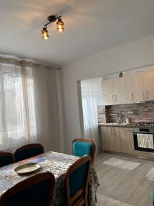uma sala de jantar com uma mesa e uma cozinha em Mary's Apartment em Suceava