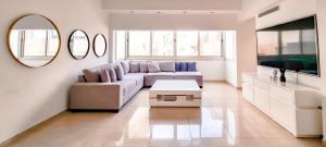uma sala de estar com um sofá e uma mesa em BnBIsrael apartments - Dizengoff Anemone em Tel Aviv