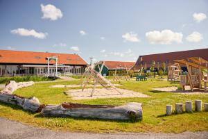 un parc avec une aire de jeux avec un toboggan et des bûches dans l'établissement Erfgoedpark De Hoop Vakantiewoningen, à Uitgeest