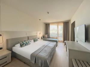 ein Schlafzimmer mit einem großen Bett und einem Sofa in der Unterkunft GRIFID Moko Beach - 24 Hours Ultra All Inclusive & Private Beach in Goldstrand
