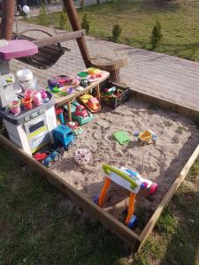 einem Sandkasten mit Spielzeug im Sand in der Unterkunft Wczasy na Kaszubach u Hani in Wiele