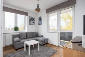 uma sala de estar com um sofá e uma mesa em Arte Praga Koneser Apartment em Varsóvia