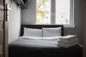uma cama num quarto com uma janela e algumas toalhas em Arte Praga Koneser Apartment em Varsóvia