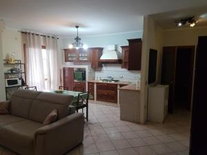 een keuken en een woonkamer met een bank en een tafel bij Just Pompei Holiday House in Scafati