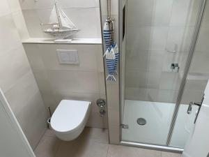 Un pequeño baño con inodoro y ducha. en Haus Uthlande Uthlande Whg 51 Meeresbrise, en Wyk auf Föhr