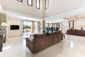 Una sala de estar con un sofá y un televisor. en 4 bedroom Villa Galinios with large private pool, Aphrodite Hills Resort, en Kouklia
