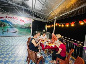 un grupo de personas sentadas en una mesa comiendo comida en Anh dược homestay en Bak Kan