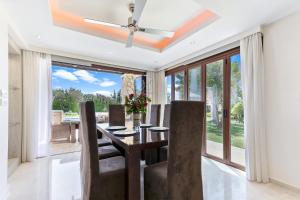 uma sala de jantar com uma mesa com cadeiras e uma ventoinha de tecto em 4 bedroom Villa Galinios with large private pool, Aphrodite Hills Resort em Kouklia