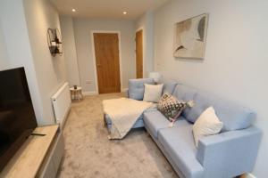 a blue couch in a living room with a television at The Hive - IH21ALL - APT 2 in Thornaby on Tees