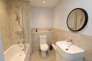a bathroom with a toilet and a sink and a mirror at The Hive - IH21ALL - APT 2 in Thornaby on Tees