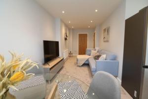 ein Wohnzimmer mit einem Glastisch und einem TV in der Unterkunft The Hive - IH21ALL - APT 2 in Thornaby on Tees