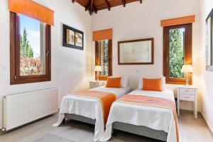 4 bedroom Villa Galinios with large private pool, Aphrodite Hills Resort في كوكليا: سريرين في غرفة بها نافذتين