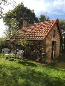 Camping Les Arbois في Montjay: منزل من الطوب مع مقعد وجدار حجري