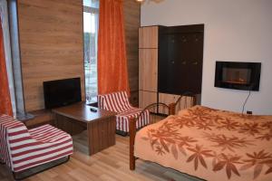 a bedroom with a bed and a table and a tv at Veteranu 5 Visaginas in Visaginas