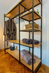 a wooden shelf with baskets and towels on it at Sofia Downtown Boutique Apartment in Sofia