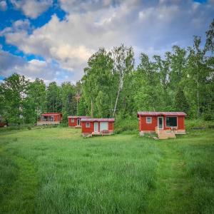 un grupo de pequeñas casas en un campo en Vägs Ände Stugor en Björkö