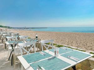 a row of tables and chairs on the beach at GRIFID Moko Beach - 24 Hours Ultra All Inclusive & Private Beach in Golden Sands